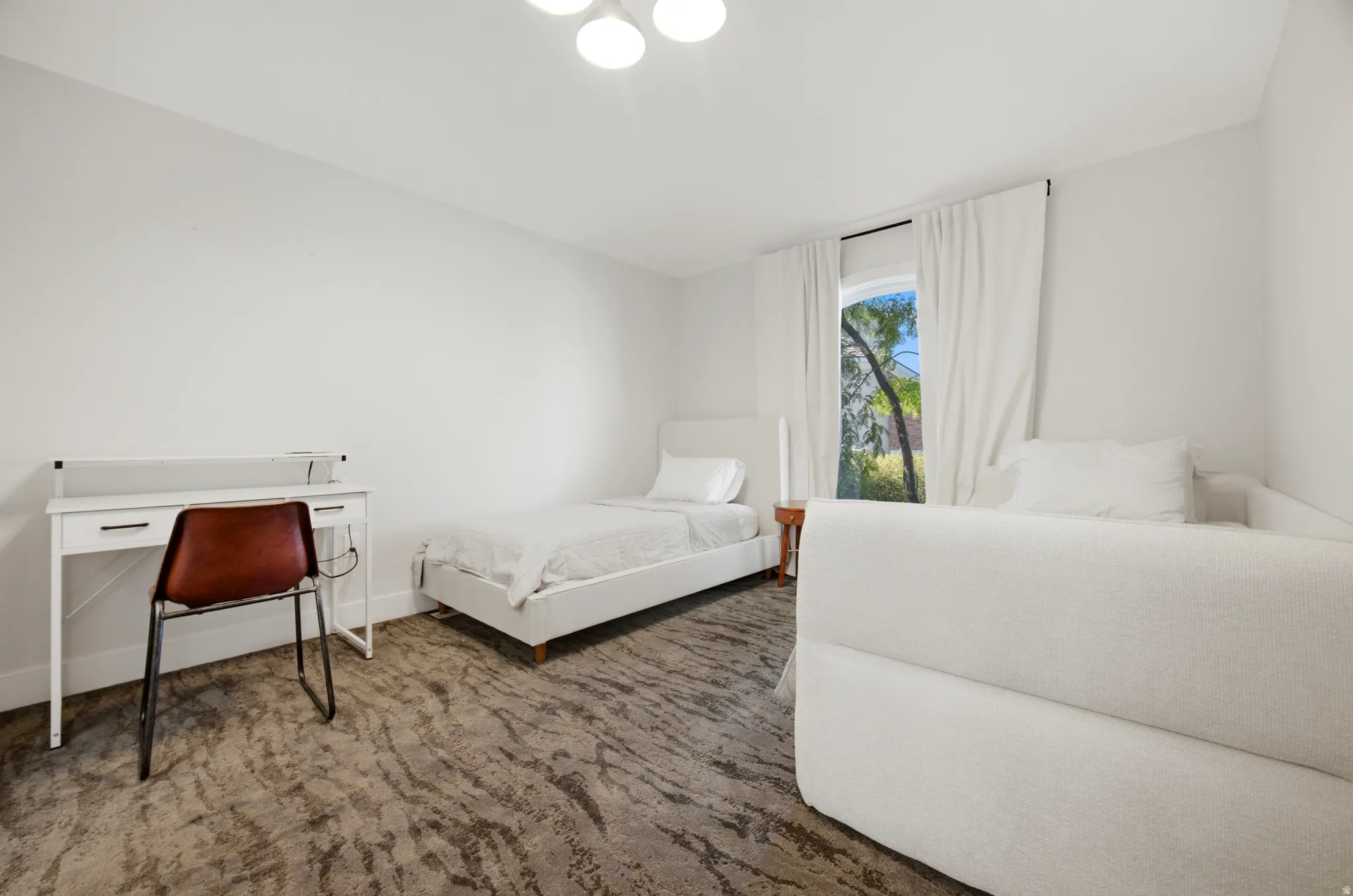 Recessed lighting, wood-finish flooring, and a window with white drapes