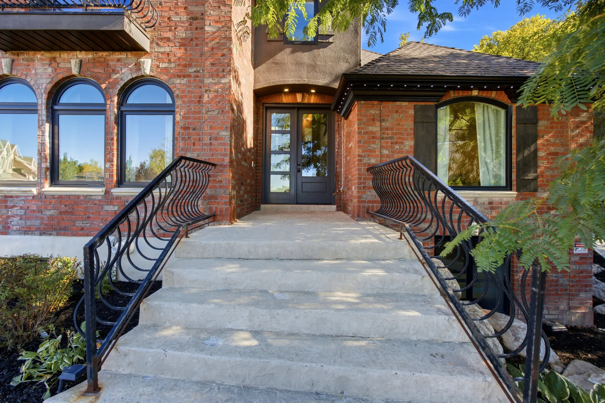 Brick exterior with arched windows and decorative wrought iron railings