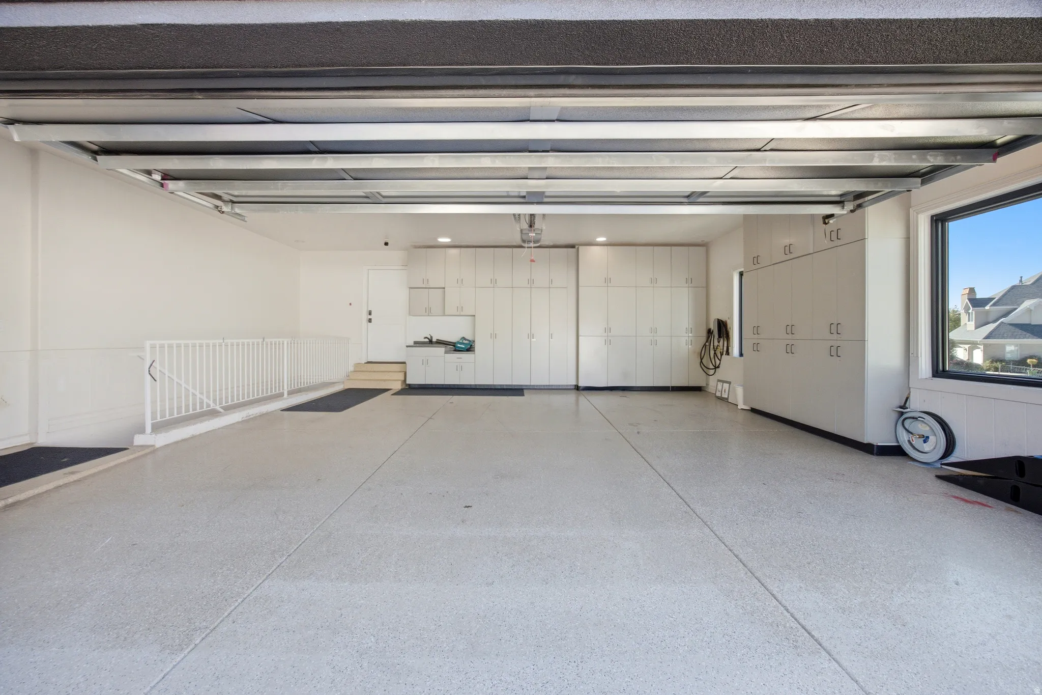 Epoxy flooring, extensive built-in cabinetry, utility sink, and large window