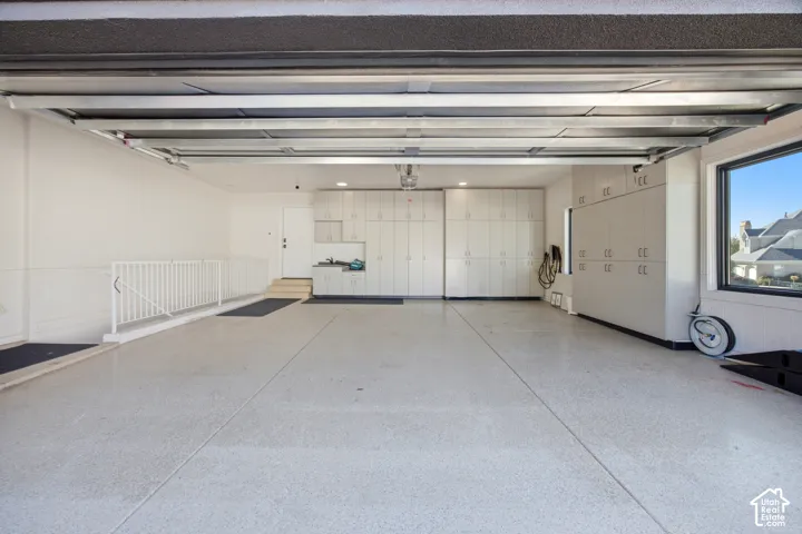 Epoxy flooring, extensive built-in cabinetry, utility sink, and large window