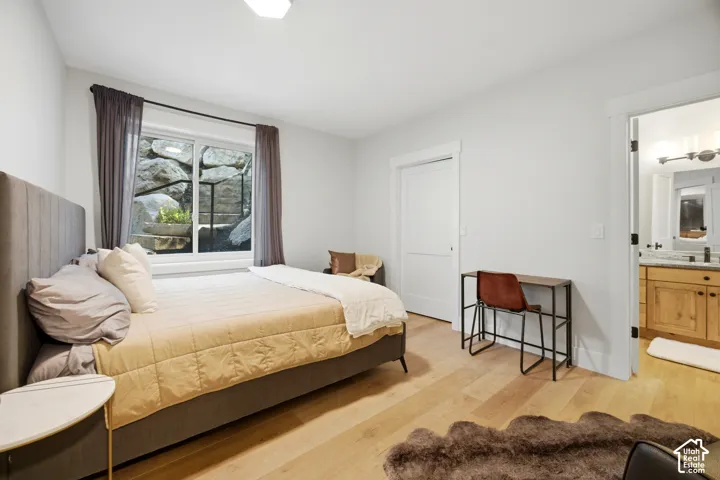 Light-toned wood-finish flooring, white walls, and a window with exterior rock landscaping
