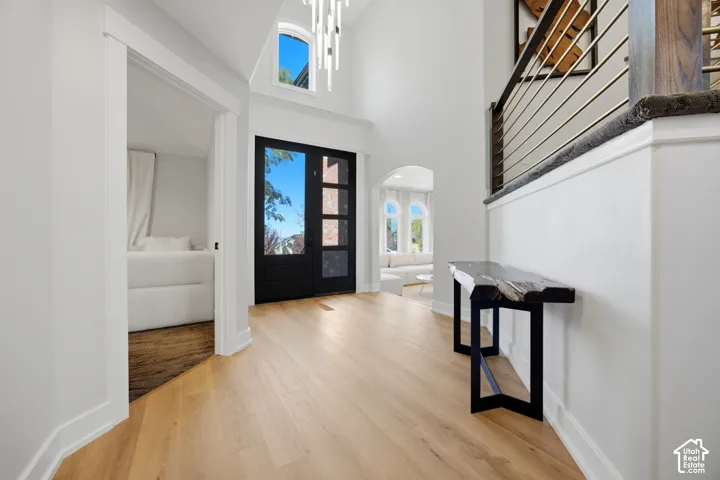 Vaulted entryway with wood-finish flooring, a two-story ceiling, and a modern chandelier