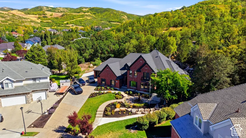Red brick exterior, black shingles, multiple gables, and terraced landscaping