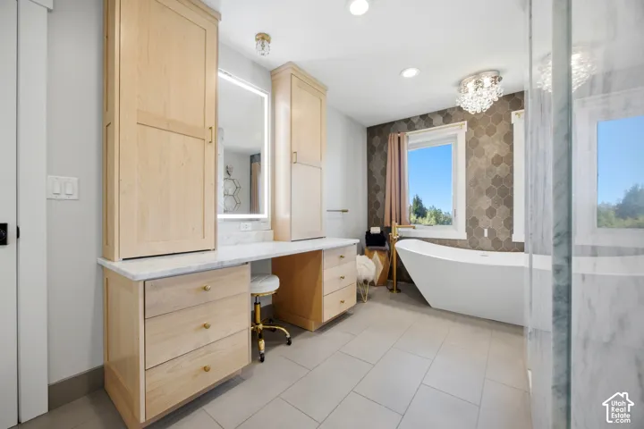 Light wood-finish cabinetry with a white countertop and integrated vanity area