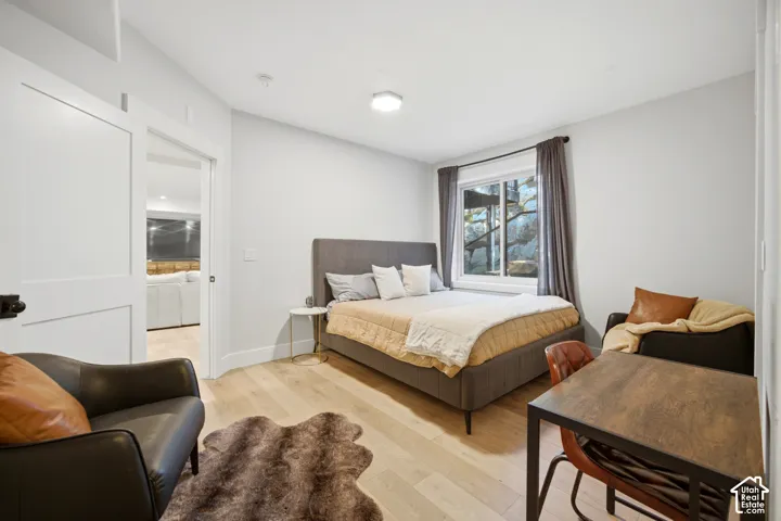 White walls, wood-finish flooring, and a sliding two-panel door