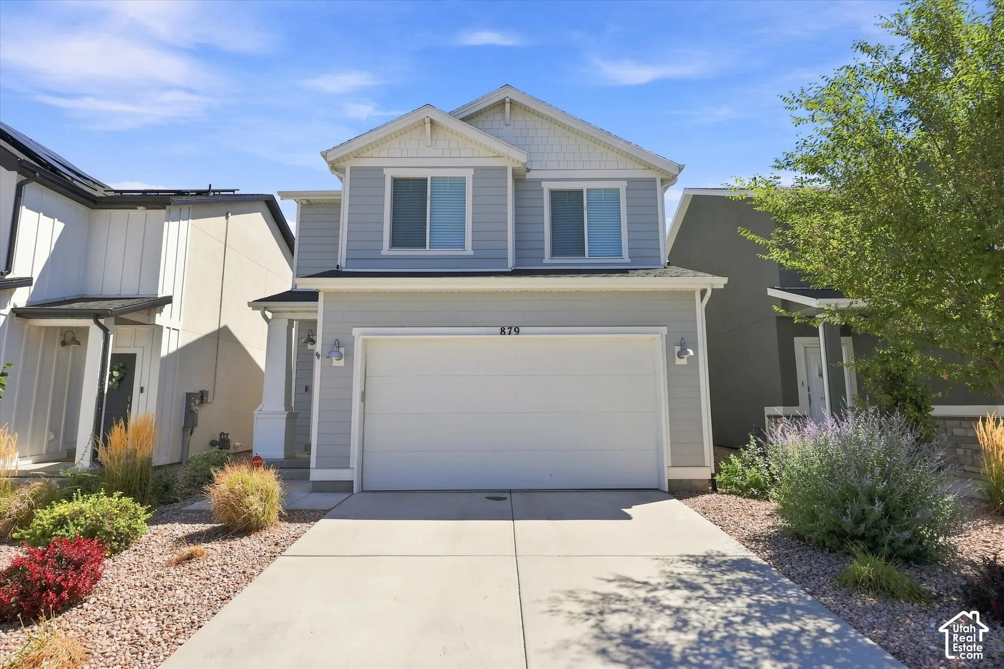 Two-story facade with light gray siding and white trim accents