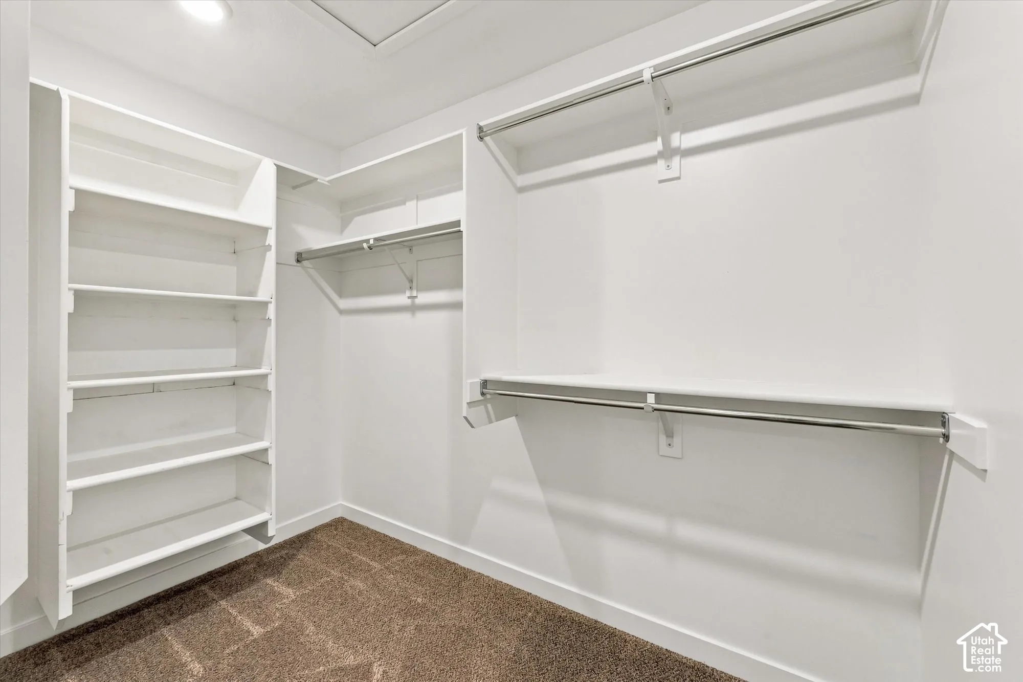 Huge Walk in Closet Built-in shelving, chrome hanging rods, and recessed lighting