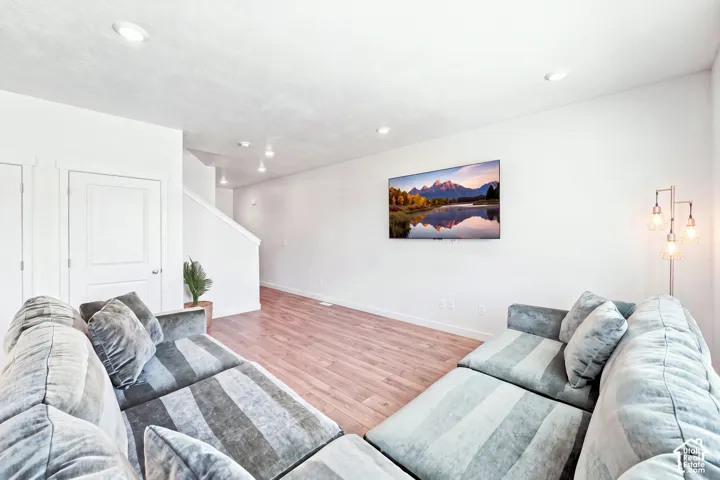 Recessed lighting throughout, wood-finish flooring "wall color is altered"