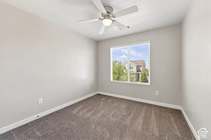 Recessed window with horizontal blinds, overhead ceiling fan with integrated lighting, and neutral-toned wall paint