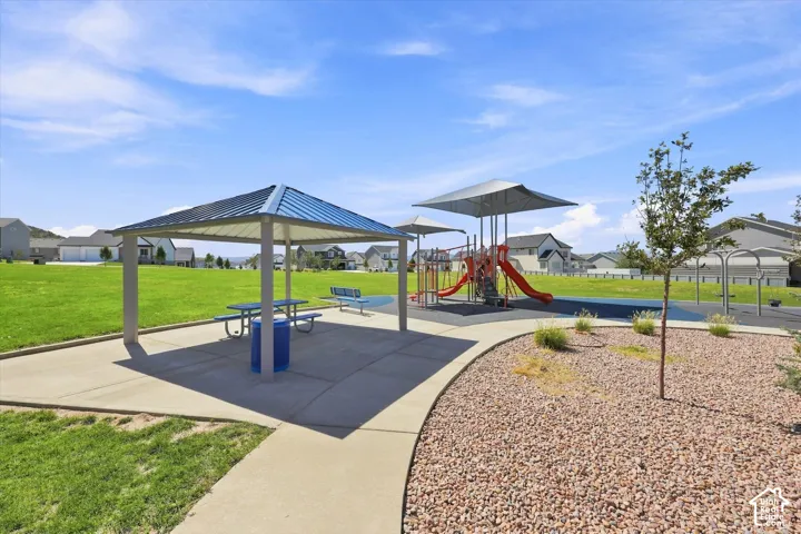 Recreational park area featuring a covered picnic shelter, playground equipment, and expansive green space