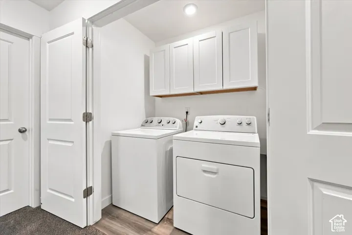 Laundry area featuring white shaker-style cabinetry, wood-finish flooring, and recessed lighting