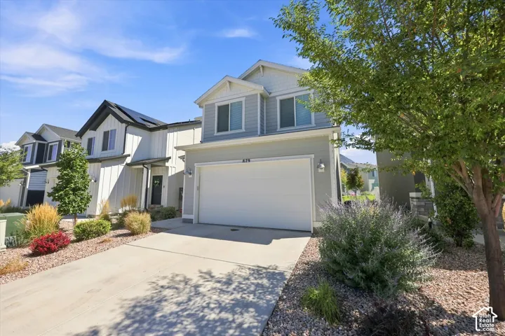 Contemporary exterior with light gray siding, white trim, attached two-car garage, and a concrete driveway