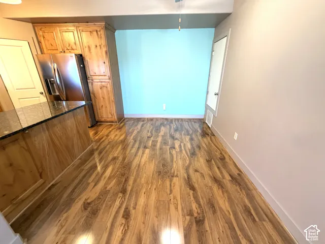 Wood-finish flooring throughout, complemented by a kitchen island with a dark countertop