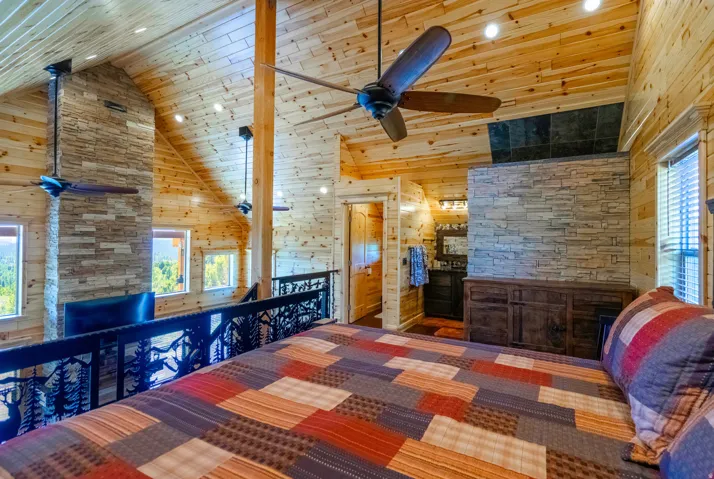 Vaulted wood-paneled ceiling with recessed lighting and ceiling fans
