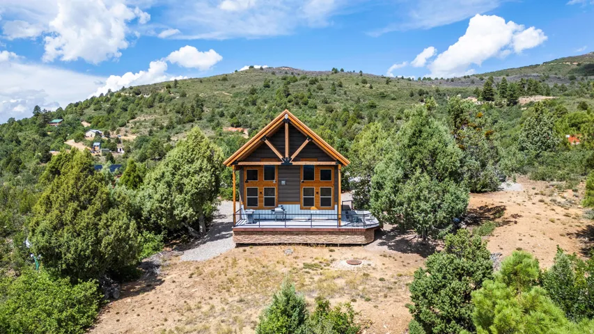 Mountain-style exterior with wood beam accents, multiple windows, and a raised outdoor deck