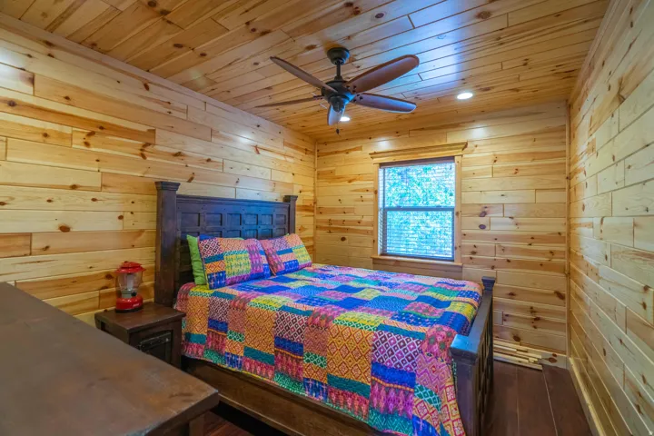 Wood-paneled walls and ceiling, dark wood-finish flooring, recessed lighting, and a ceiling fan