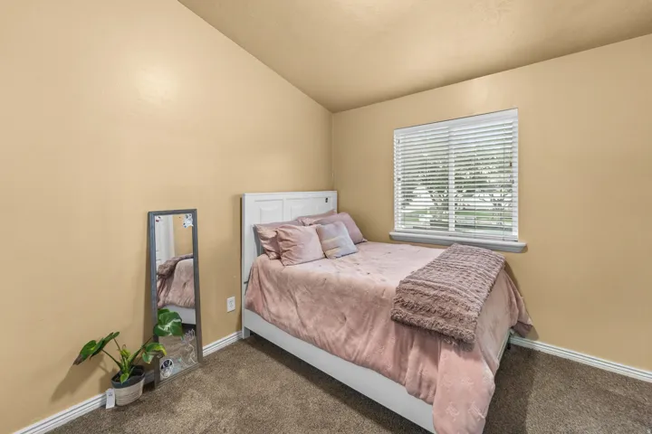 Second Bedroom Carpeted flooring, vaulted ceiling, and window with blinds