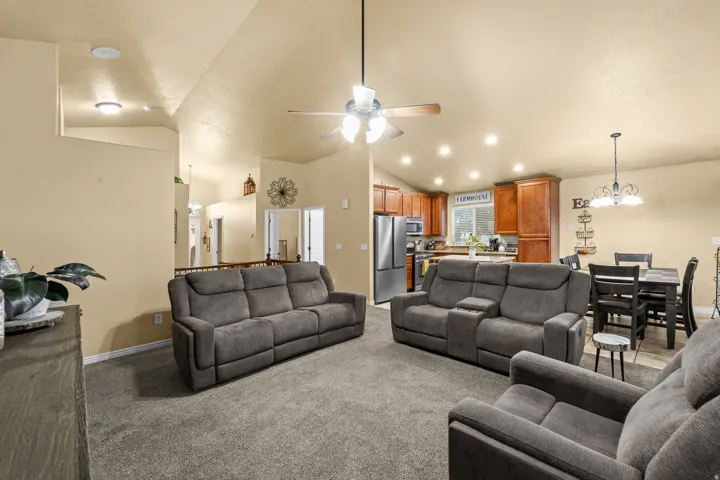Vaulted ceilings, recessed lighting, ceiling fan, wood-finish cabinetry, and stainless steel appliances