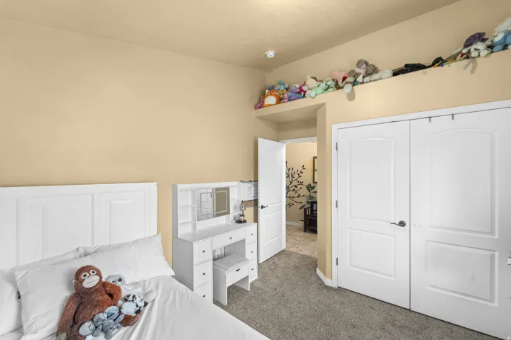 Front Bedroom Built-in shelving, two-panel interior doors, and neutral carpeting