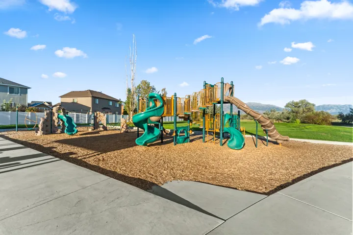 Community playground featuring multiple slides, climbing structures, and a wood chip surface
