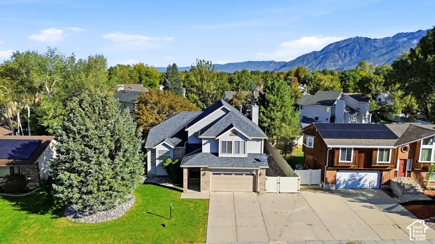 Two-story residence with a multi-gabled roof, attached two-car garage, and a paved driveway