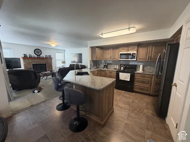 Kitchen with wood cabinetry, light-toned countertops, and a gray tile backsplash