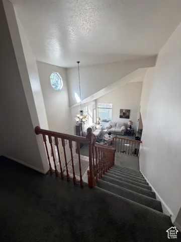Vaulted ceiling, hexagonal window, wood-finish stair railing, wall-mounted chandelier