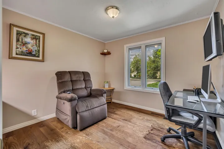 Hardwood-finish flooring, neutral wall paint, and a large window with white trim
