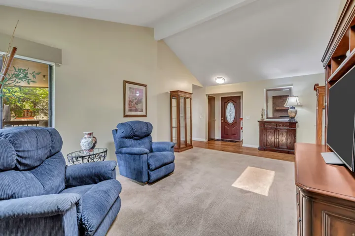 Vaulted ceilings, carpeted flooring, wood-finish flooring, and a sliding glass door