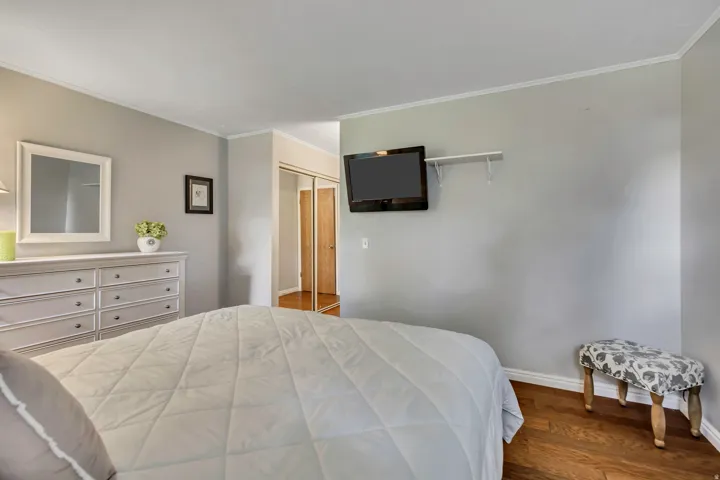 Hardwood-finish flooring, light gray wall color, white crown molding, white baseboards, wood doors