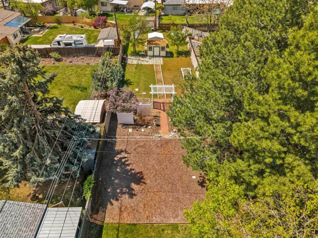 Expansive outdoor space featuring a paved area, green lawn, and mature trees