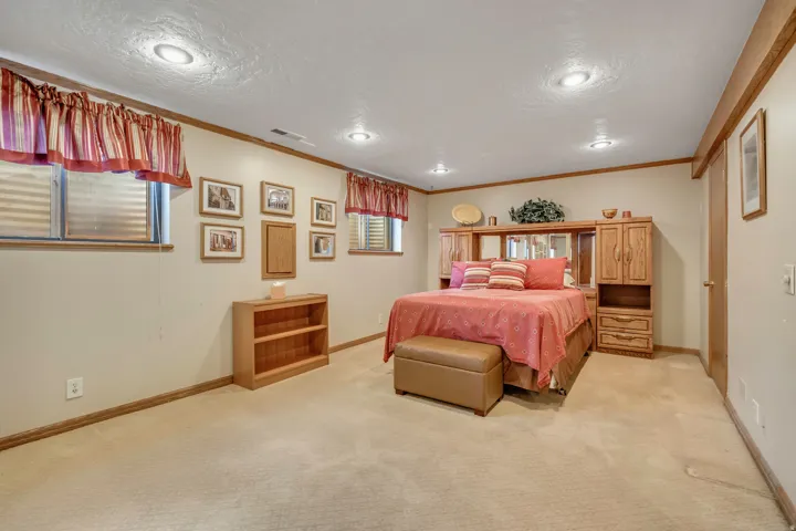 Recessed ceiling lighting, light-toned wall paint, wood trim, and carpeted flooring