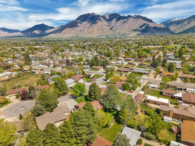 Residential neighborhood with mature trees and mountain backdrop