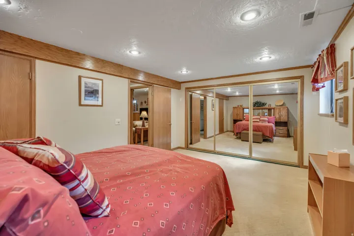 Recessed lighting, wood trim details, light-colored carpeting, mirrored closet doors, and wood-finish interior doors