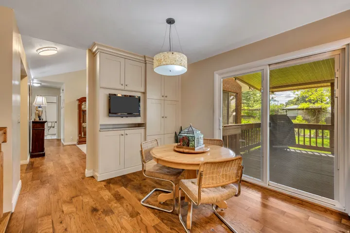 Hardwood flooring, built-in cabinetry, sliding glass door, recessed lighting, and a deck