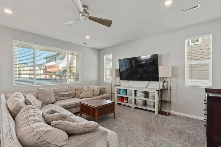 Recessed lighting illuminates the space, complemented by a ceiling fan