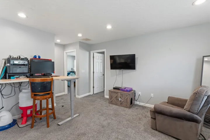 Recessed ceiling lighting, light gray wall paint, and gray carpeting