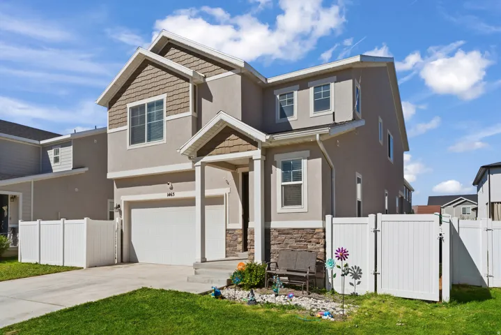 Two-story exterior with stucco and shake siding accents, a covered entry, and an attached garage