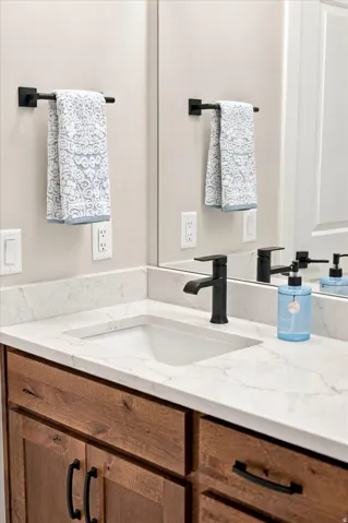 White rectangular under-mount sink with a single-hole matte black faucet.