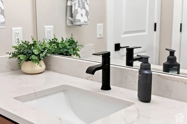 Integrated rectangular sink with a matte black faucet, set into a stone-look countertop.