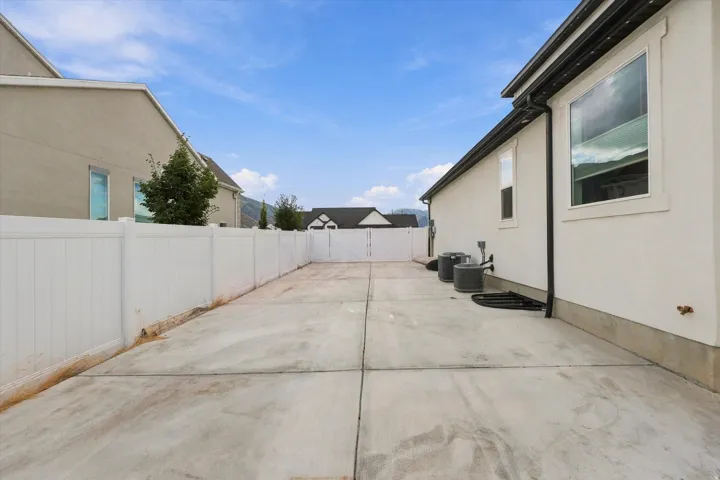 Concrete hardscaping with a white privacy fence. Large RV pad.