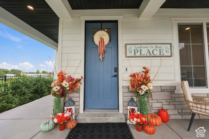 Covered wrap around front porch featuring white siding and a blue entry door.