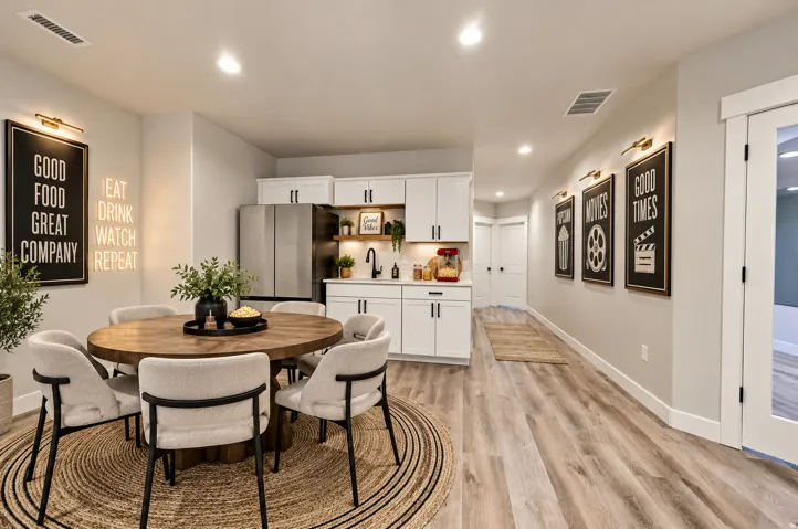 Virtually Staged for Decor Ideas. Integrated wet bar featuring white cabinetry, stainless steel refrigerator, and a dark-toned sink