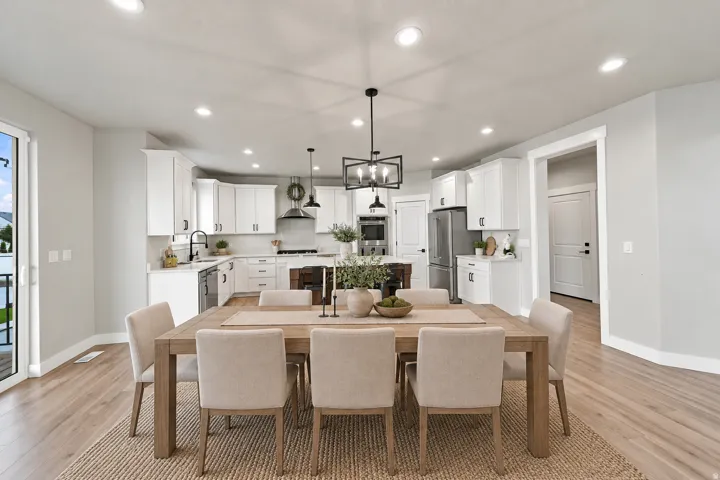 Virtually Staged for Decor Ideas. Bright kitchen featuring white cabinetry, stainless steel appliances, a center island, and wood-finish flooring