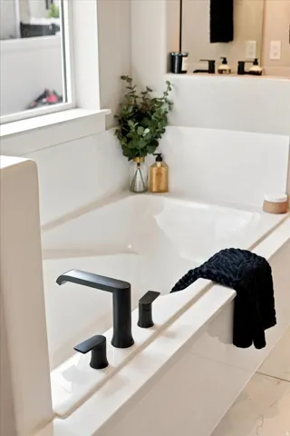 Deep soaking tub with matte black fixtures.