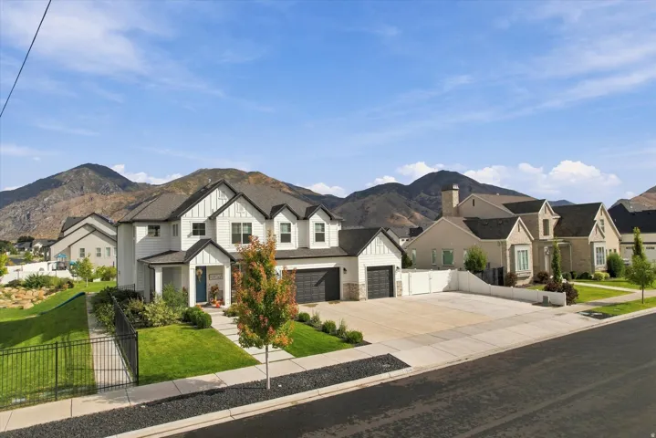 Modern farmhouse style exterior with a two-car garage, established front yard landscaping, and mountain backdrop.