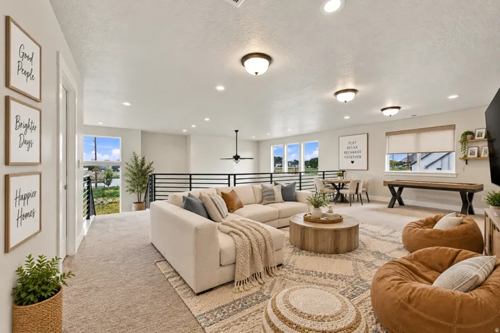 Spacious bonus room featuring multiple windows, recessed lighting, and a modern horizontal railing.