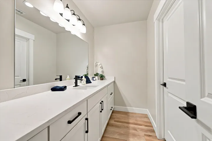 Large bathroom with white shaker-style cabinetry and black hardware.