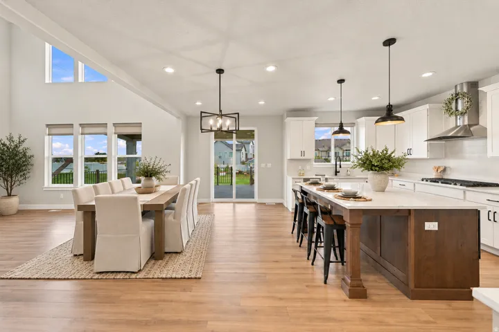 Virtually Staged for Decor Ideas. Open-concept living space with wood-finish flooring, a vaulted ceiling, and recessed lighting