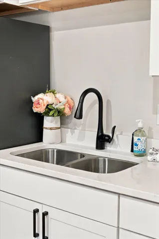 Double-basin stainless steel sink with a matte black faucet, set into a light-toned countertop.